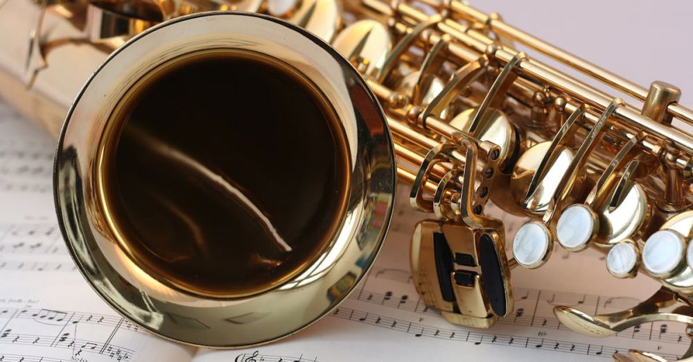 Instruments - A detailed view of a saxophone resting on sheet music, highlighting its brass finish.