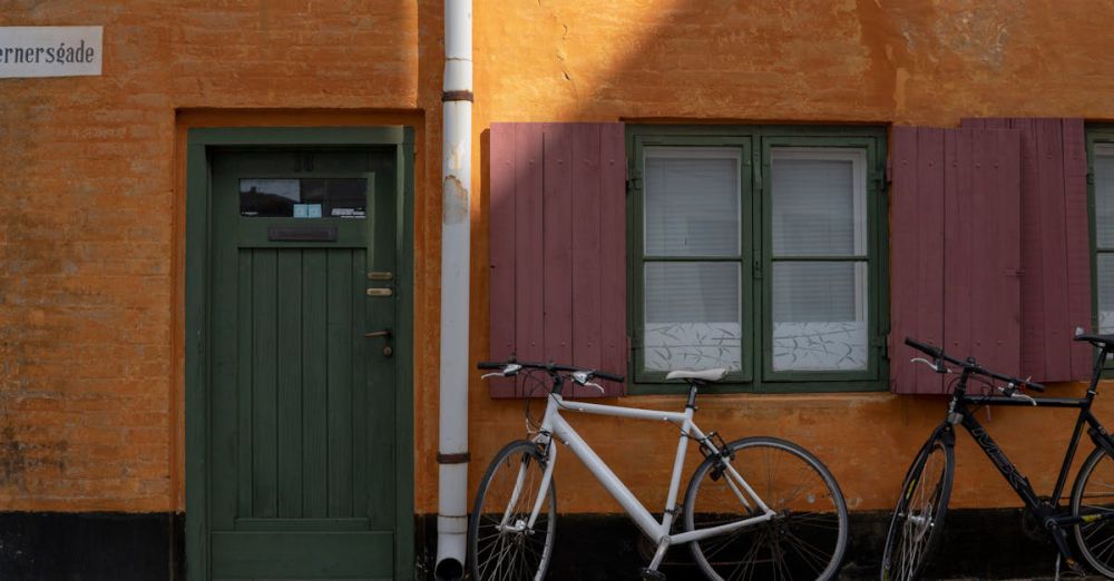 Vintage Bicycles - A vibrant street scene in Kjellerup, Denmark, featuring colorful house facades and parked bicycles.