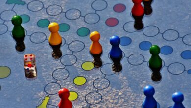 Board Games - Close-up of a colorful board game with pawns and a dice, perfect for family fun.