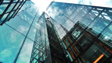 Companies - A striking view of a modern glass skyscraper reflecting the sky and clouds.