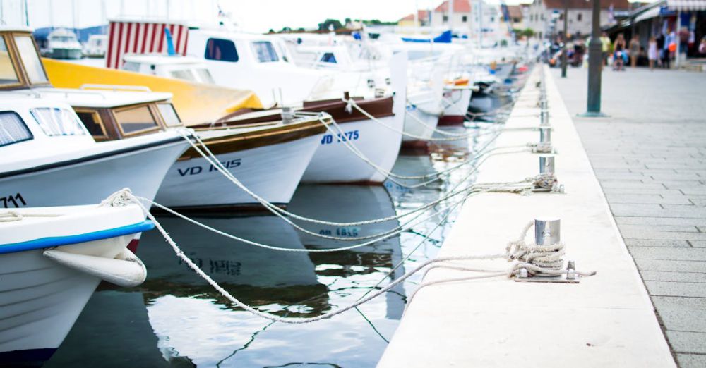 Boats - A collection of boats moored at a harbor pier on a clear day. Perfect for travel and maritime themes.