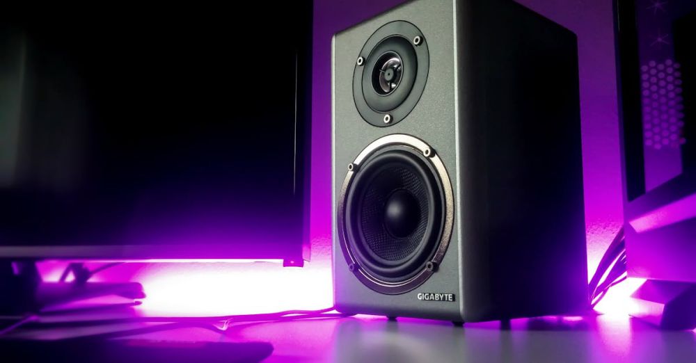 Speakers - High-quality speaker setup with vibrant purple lighting in a modern studio setting.