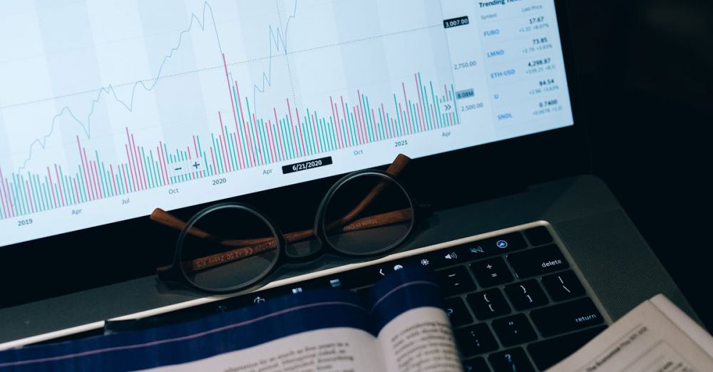 Risks - Close-up of laptop screen with business analytics, book, and eyeglasses.