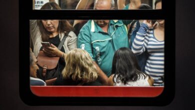 Peak Time - View through a train window revealing crowded commuters standing during a busy commute.