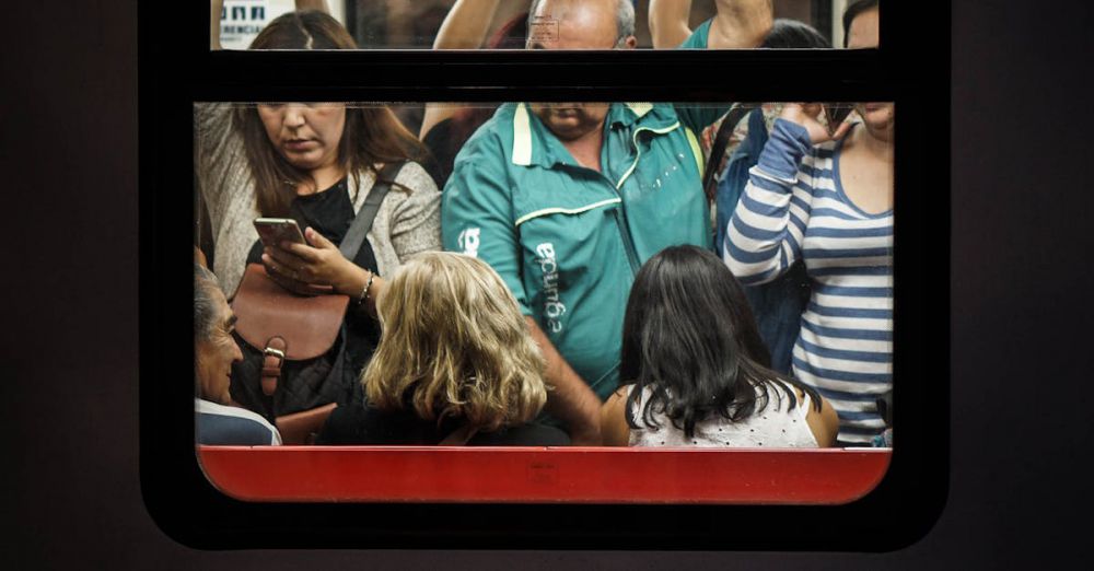 Peak Time - View through a train window revealing crowded commuters standing during a busy commute.