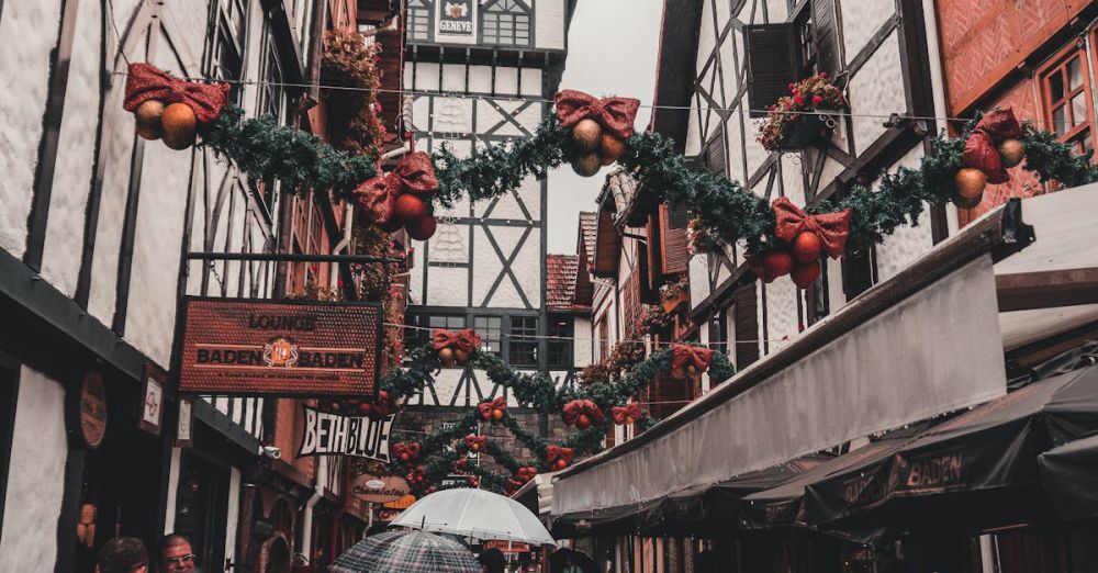 December - Charming street adorned with Christmas decorations and people walking with umbrellas.