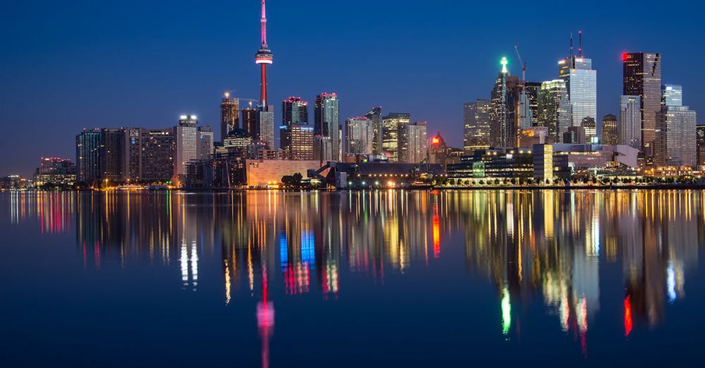 Toronto - Stunning night view of Toronto skyline reflecting on water with CN Tower prominent.