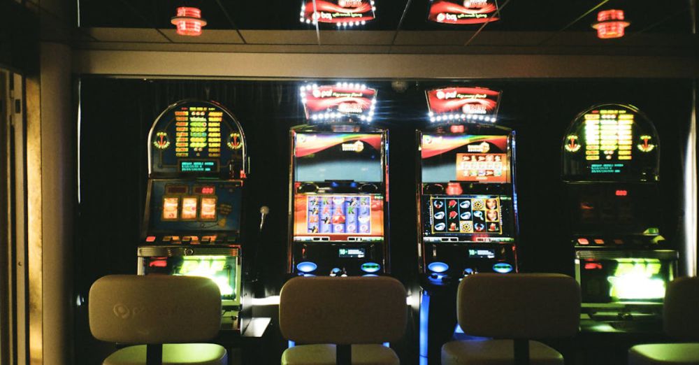 Chances - Slot machines in a dimly lit casino with reflective ceiling and empty chairs.