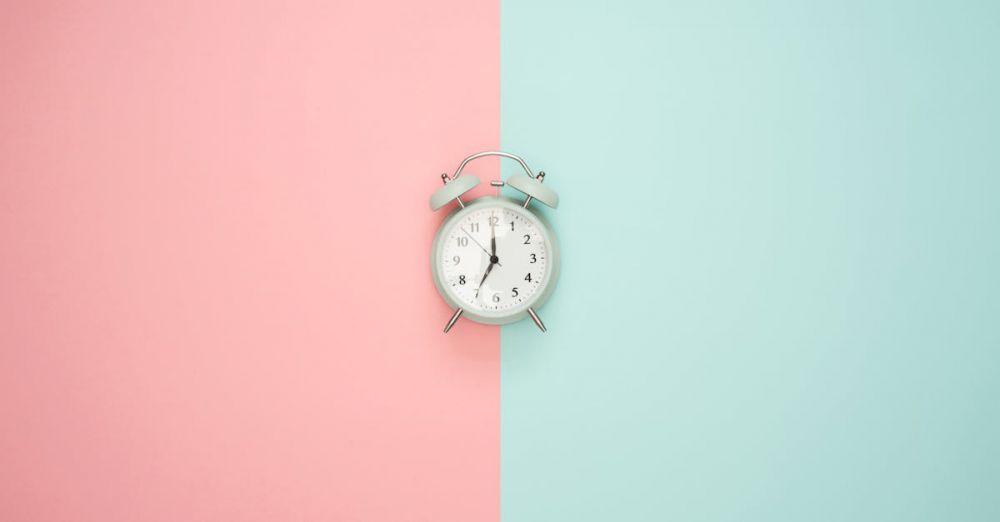 Time - A vintage round clock on a split pastel pink and blue background.