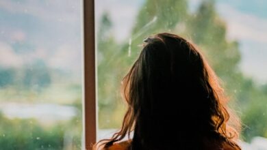 Miss - Silhouette of a woman looking out a window at a scenic mountain view in Cajamarca, Peru.