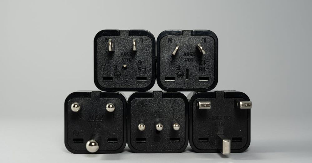 Plugs - A collection of various black international power plug adapters for global electronics use.