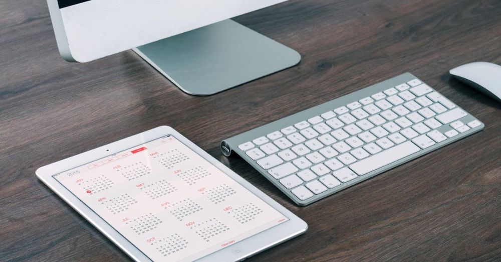 Months - A sleek and modern office desk setup featuring an iMac, iPad with calendar, keyboard, and mouse.