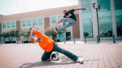 Beginners - Two men performing breakdancing moves in an urban outdoor setting.