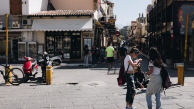 Rentals - Street view of Chania, Greece featuring people, shops, and urban life under sunny skies.