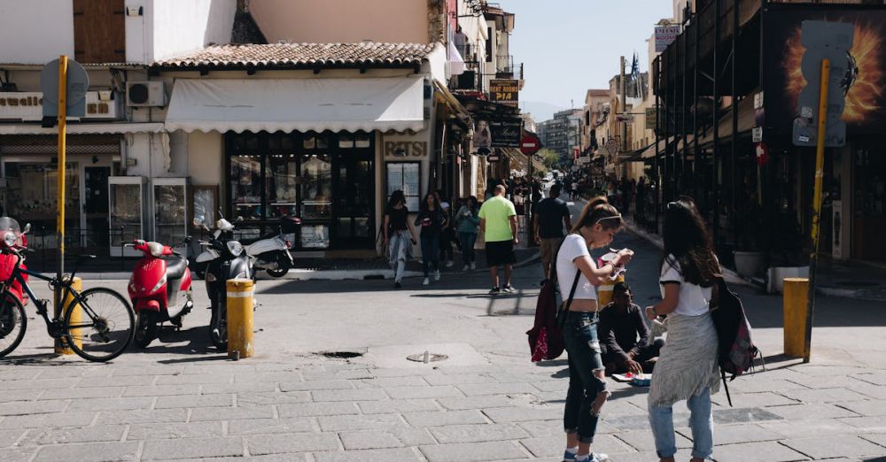 Rentals - Street view of Chania, Greece featuring people, shops, and urban life under sunny skies.