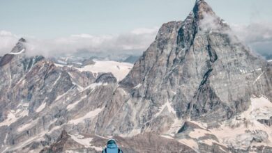 Skiing Vs Snowboarding - A mountaineer stands facing the iconic Matterhorn in Zermatt, Switzerland for an adventurous climb.