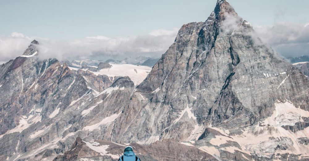 Skiing Vs Snowboarding - A mountaineer stands facing the iconic Matterhorn in Zermatt, Switzerland for an adventurous climb.