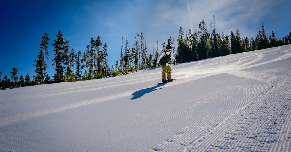 Budget Skiing - A person snowboarding down a snowy slope