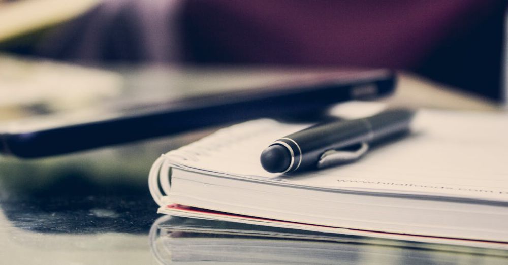 Booking - Close-up of an elegant pen resting on an open notebook in a stylish office environment.