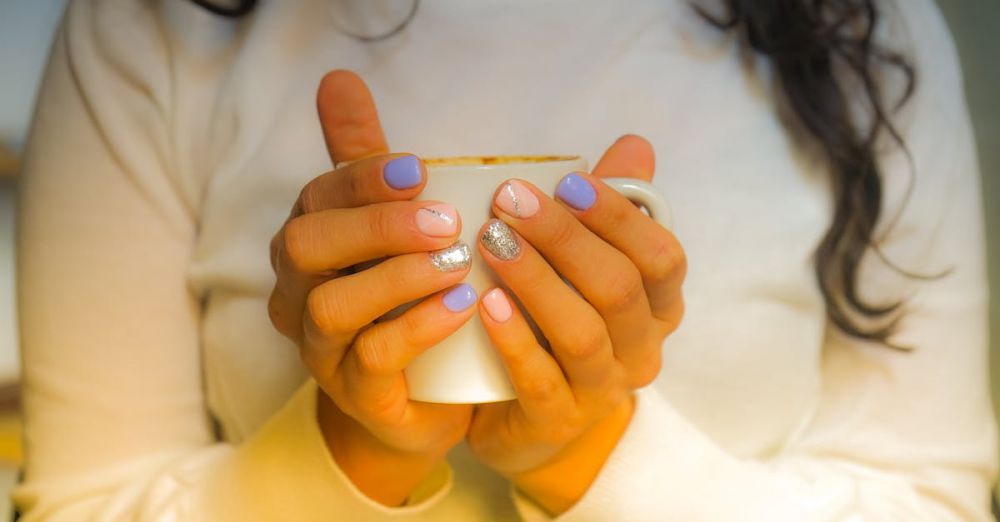 Warmth - Warm image of a woman holding a coffee cup with colorful nails in Barcelona.