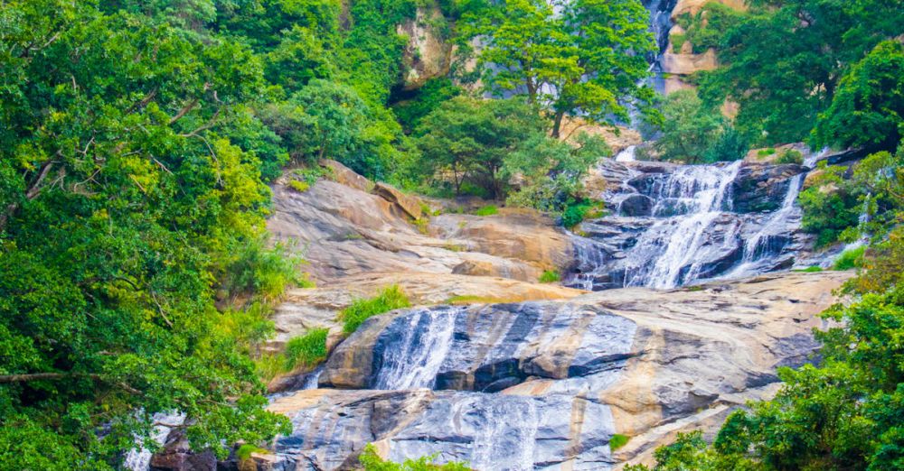 Beautiful Trails - A breathtaking view of a cascading waterfall surrounded by lush greenery, perfect for nature enthusiasts.