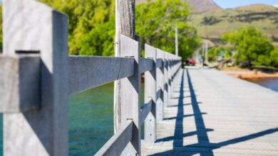 Spring Trails - Explore the beauty of a wooden bridge with mountain views and vibrant greenery in Queenstown, New Zealand.