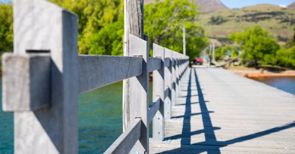 Spring Trails - Explore the beauty of a wooden bridge with mountain views and vibrant greenery in Queenstown, New Zealand.