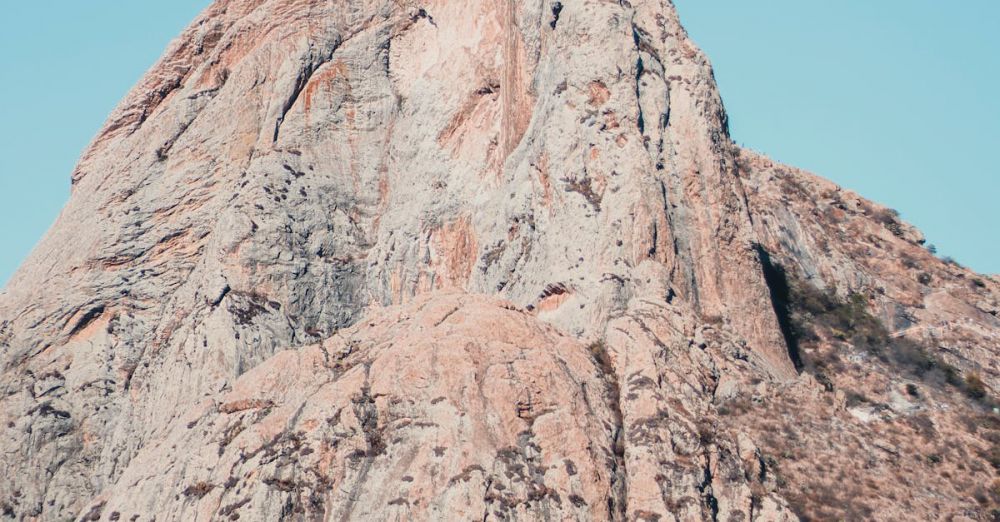 Photogenic Trails - Majestic rocky mountain peak standing tall under a clear blue sky, perfect for travel and nature enthusiasts.