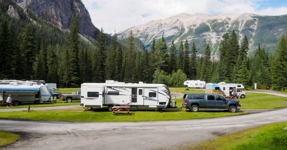 RVs - A beautiful campsite featuring RVs amidst lush forests and towering mountains for a peaceful getaway.