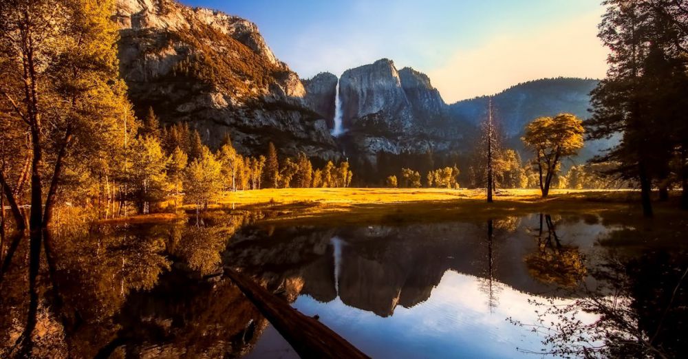 National Parks - Scenic view of Yosemite National Park showcasing a waterfall and clear reflections in tranquil water.