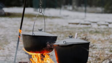 Winter Camping - A cozy winter scene showing outdoor cooking over an open fire with snow all around.