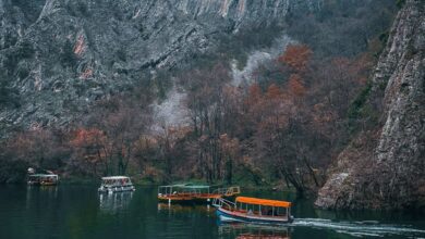 Popular Campsites - Boats cruising Matka Canyon's serene waters with majestic limestone cliffs and autumn foliage.