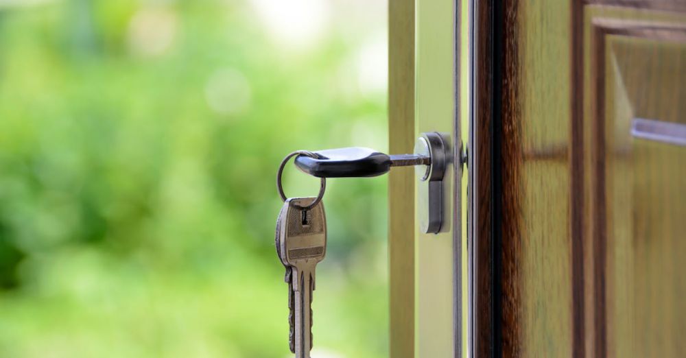 Locks - Key inserted in door lock against a blurred green background, symbolizing security and real estate.