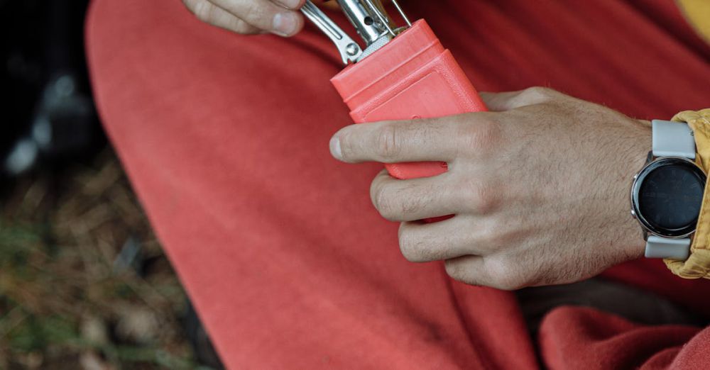 Eco-Friendly Camping - Man preparing a portable stove while camping outdoors with gear.