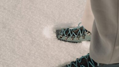 Hiking - Two pairs of hiking boots with colorful laces on pristine winter snow. Perfect for adventure and travel themes.