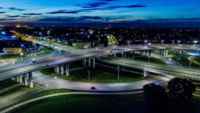 Transportation - A dramatic cityscape featuring a modern flyover lit by vibrant city lights at night.