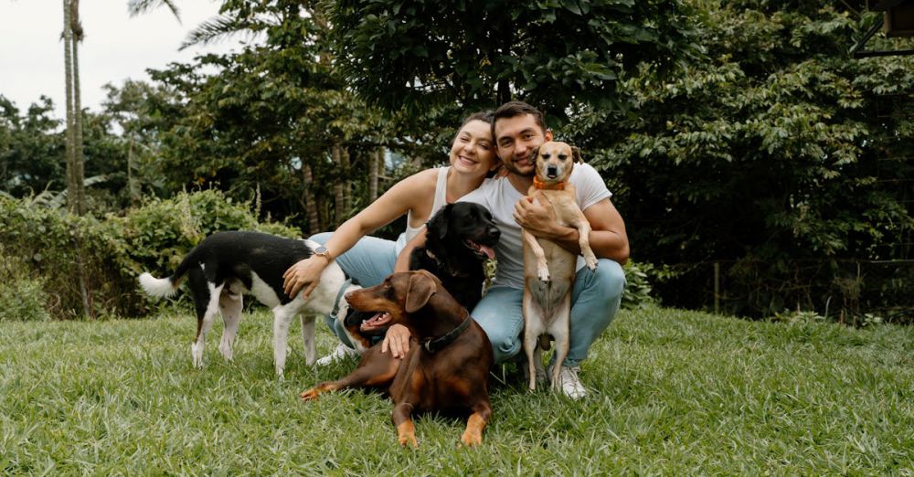 Family Parks - A joyful couple poses with their dogs in a lush garden setting, capturing a moment of happiness.