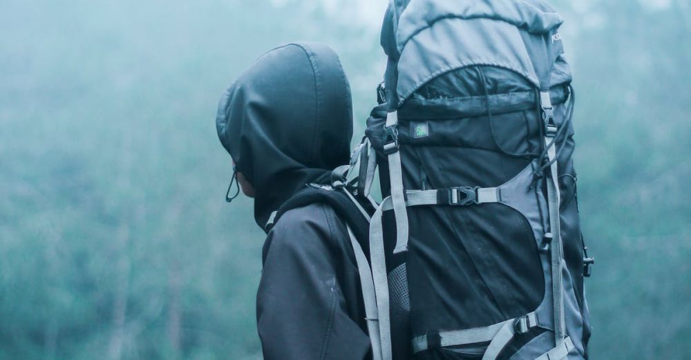 Backpacking - Solo hiker with large backpack in a misty forest, exploring nature's serene beauty.