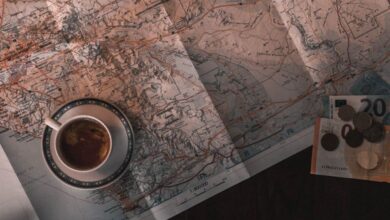 Budget Exploration - Flat lay of map, coffee, coins, and notebook for travel planning.