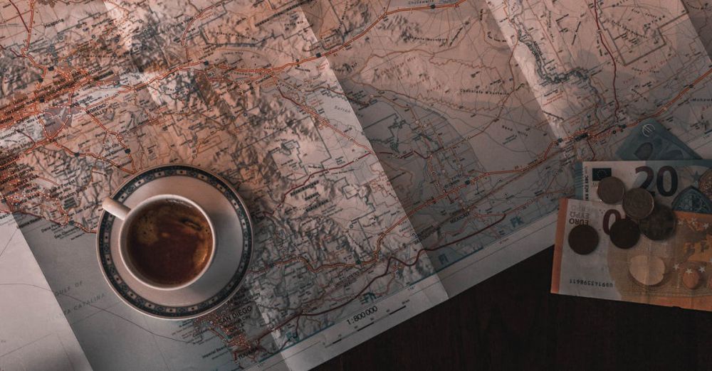 Budget Exploration - Flat lay of map, coffee, coins, and notebook for travel planning.