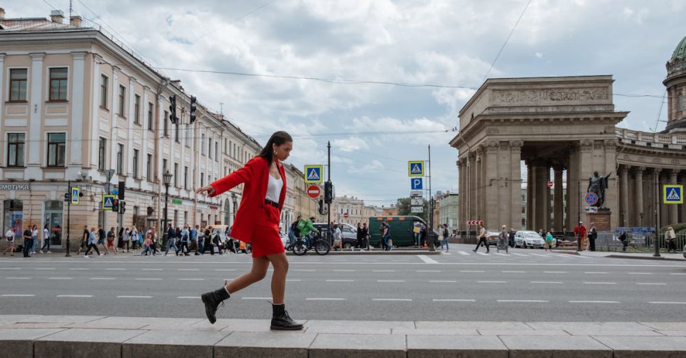 Walking Tour Wear - A woman in a fashionable red suit walks near the Kazan Cathedral in Saint Petersburg, Russia.