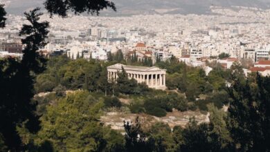 History Tours - Panoramic view of Athens cityscape with ancient temple surrounded by greenery.