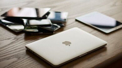 Devices - A variety of modern electronic gadgets, including a laptop and smartphones, on a wooden table.