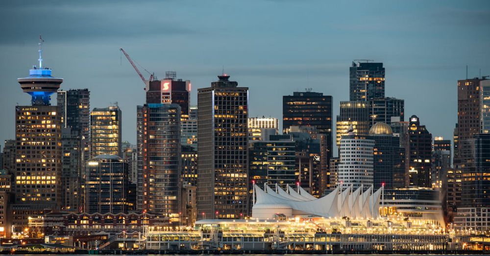 Vancouver Tours - Twilight view of Vancouver skyline featuring iconic Canada Place and skyscrapers reflecting city lights.