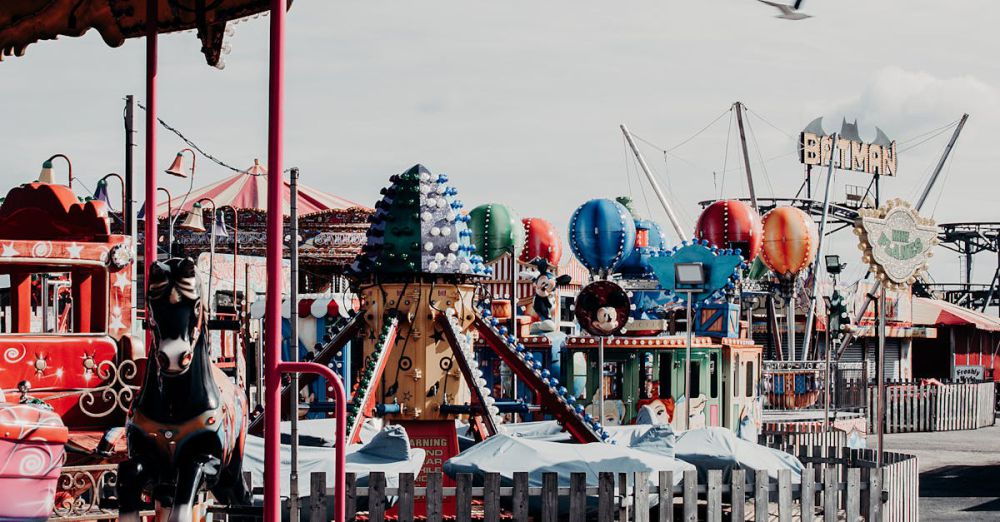 Family Tours - A lively amusement park scene featuring various rides and a carousel on a bright day.