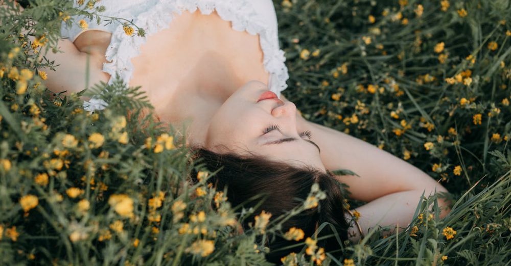 Off-the-Beaten-Path - A young woman in a white dress lies peacefully in a field of yellow flowers, exuding tranquility and beauty.