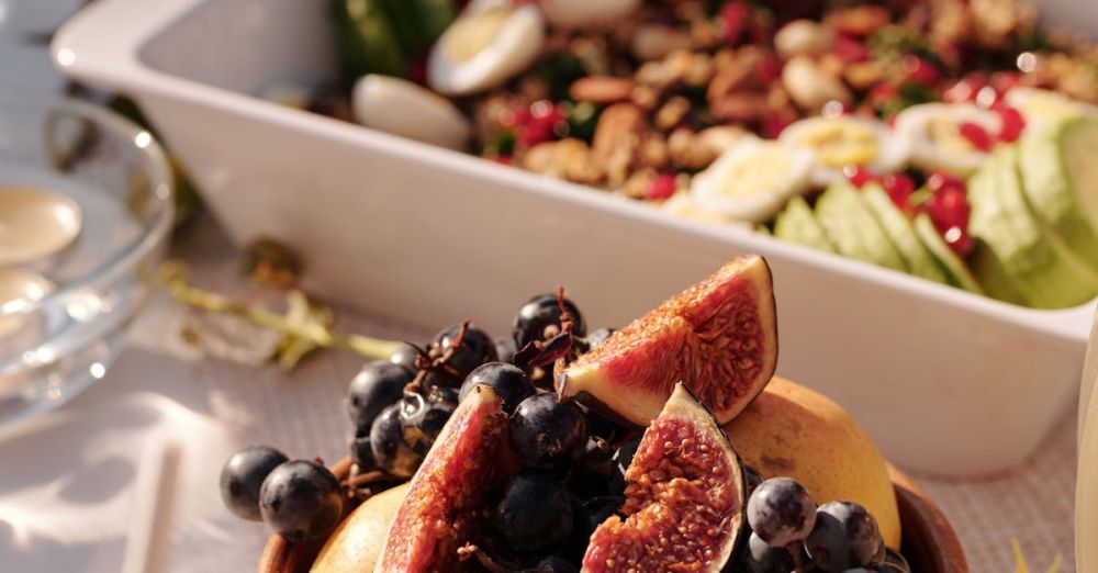 Vegetarian Festivals - High angle of ceramic plate with fresh fruits and berries on table with various snacks