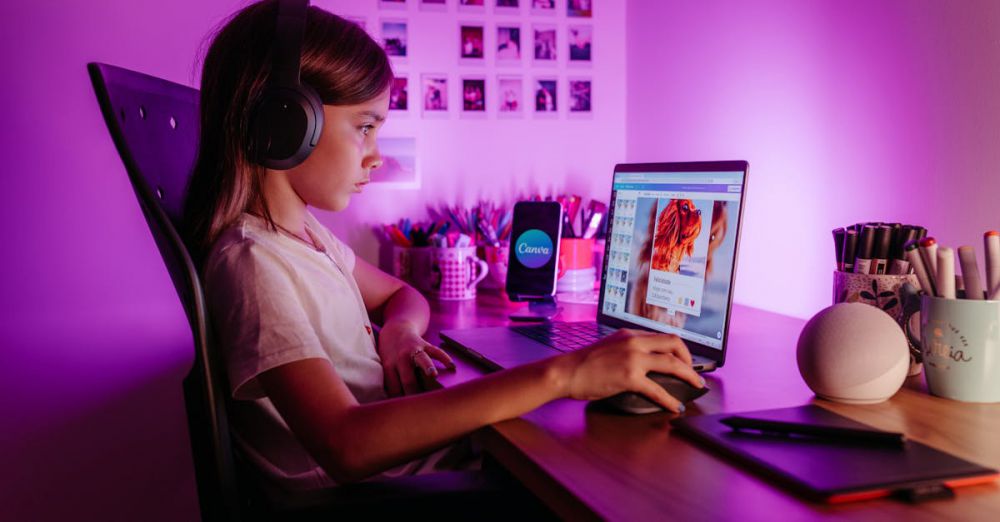 Keyboards - Child focused on laptop wearing headphones at desk with purple lighting. Modern tech scene.