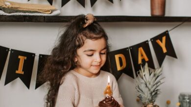 Dessert Festivals - Young girl enjoying her birthday with a cupcake in a cozy setting.