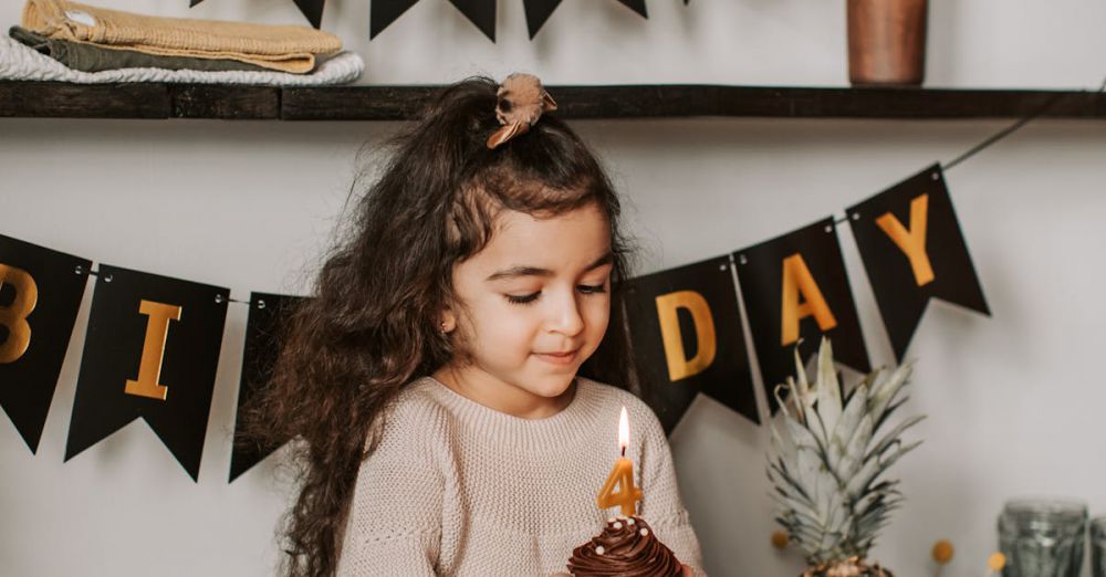 Dessert Festivals - Young girl enjoying her birthday with a cupcake in a cozy setting.